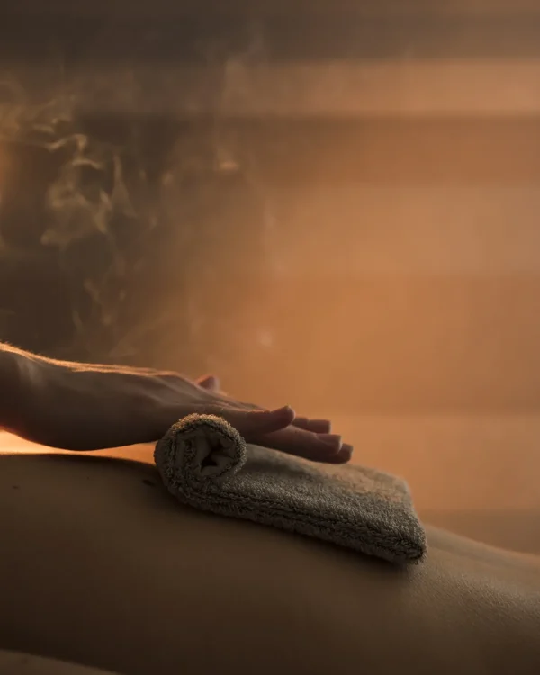 close-up-therapist-hand-massaging-woman-s-back-with-hot-towel-spa